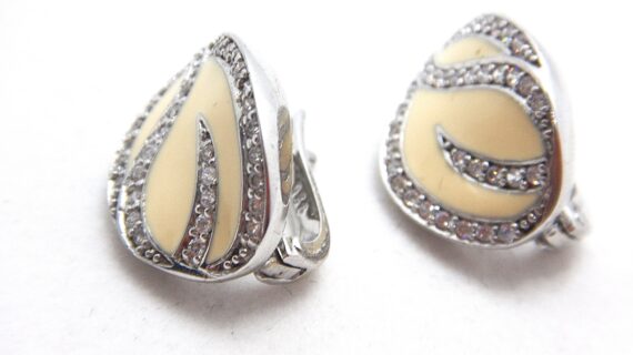 Rhodium plated 925 sterling silver oval shaped stud earrings with cream enamel set with white cubic zirconia Approx size 20.5mm x 15.5mm