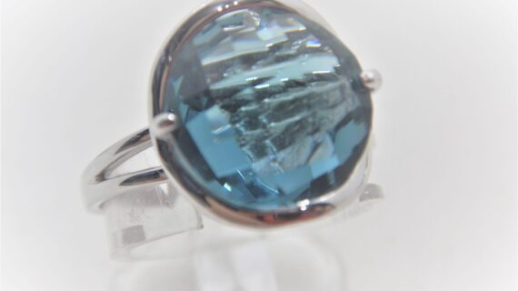 Rhodium plated 925 sterling silver ring set with synthetic blue stone Approx size  14mm diam